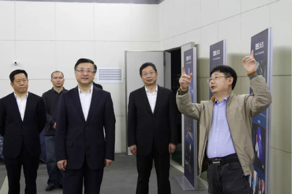 上海市委常委、市委政法委書記陳寅（中）、閔行區區委書記朱芝鬆（右二）、區委（wěi）常委、政法委書記劉豫峰（左一）聽取上海三（sān）思總裁王鷹華（右一）介紹LED相關技術和產品